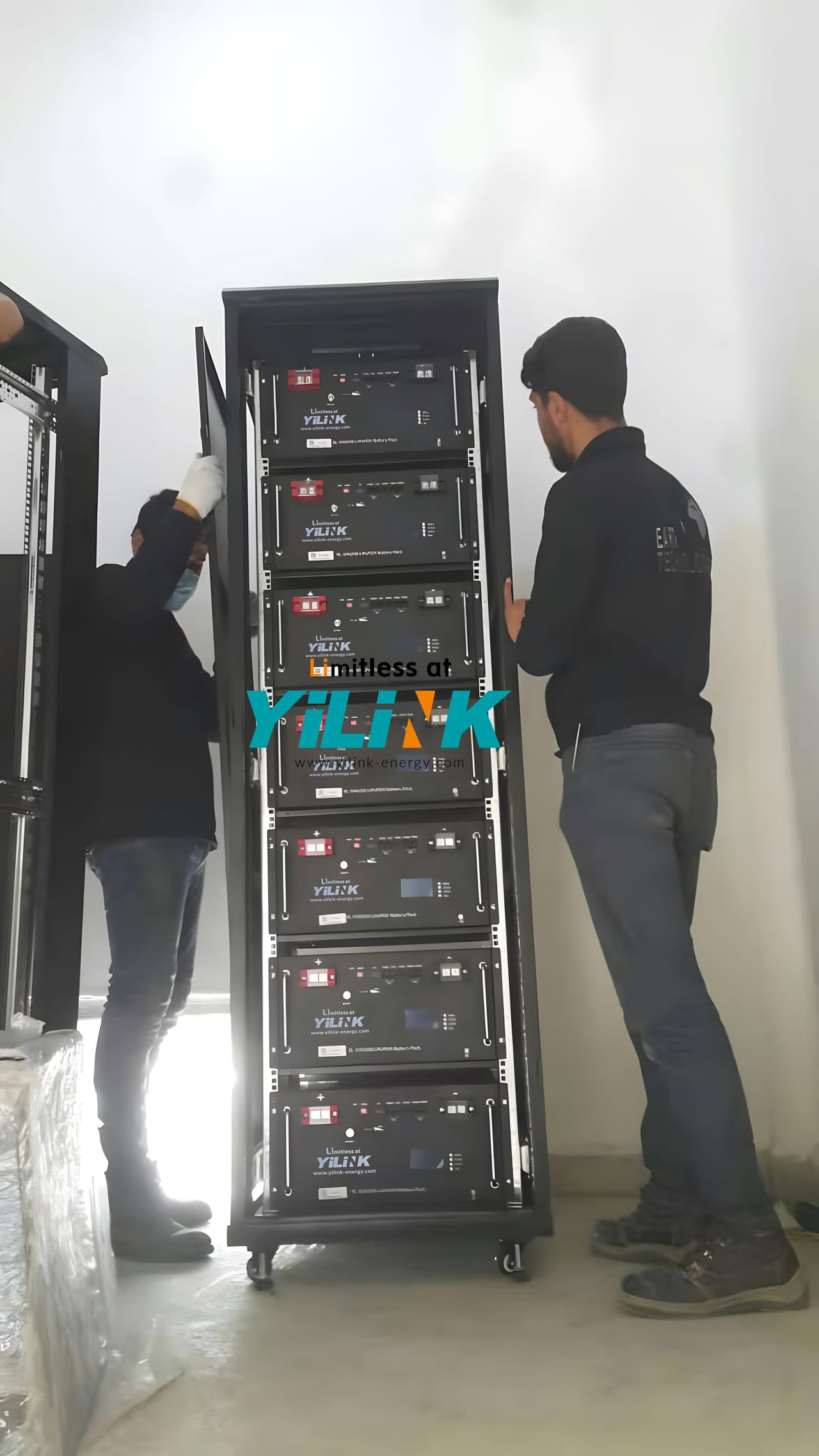 Deux techniciens assemblant une baie de batteries Yilink de 70 kWh