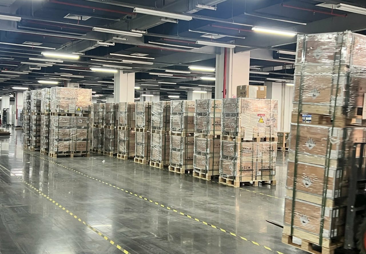 Vue d'ensemble de l'entrepôt de Saguenay et de ses palettes de batteries Yilink en caisses de bois